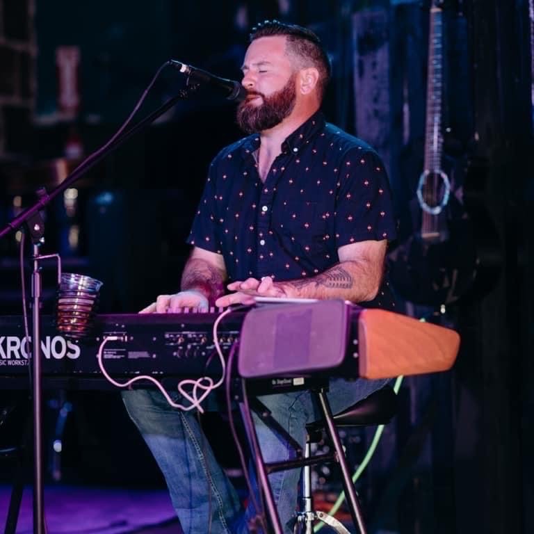 Dan performing on Kronos keyboard under purple light