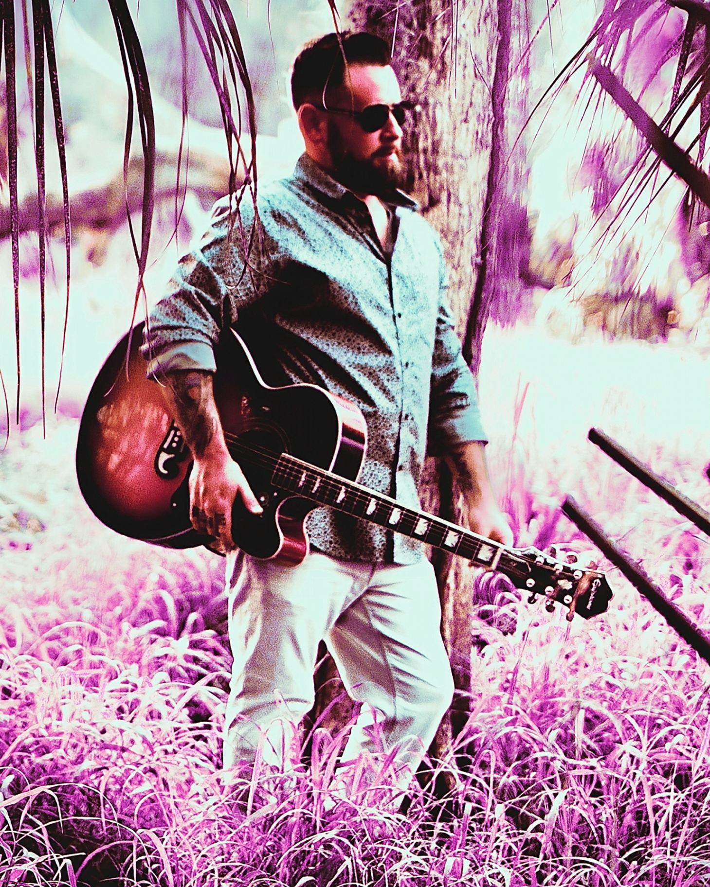 Dan Signor with acoustic guitar in a tropical setting