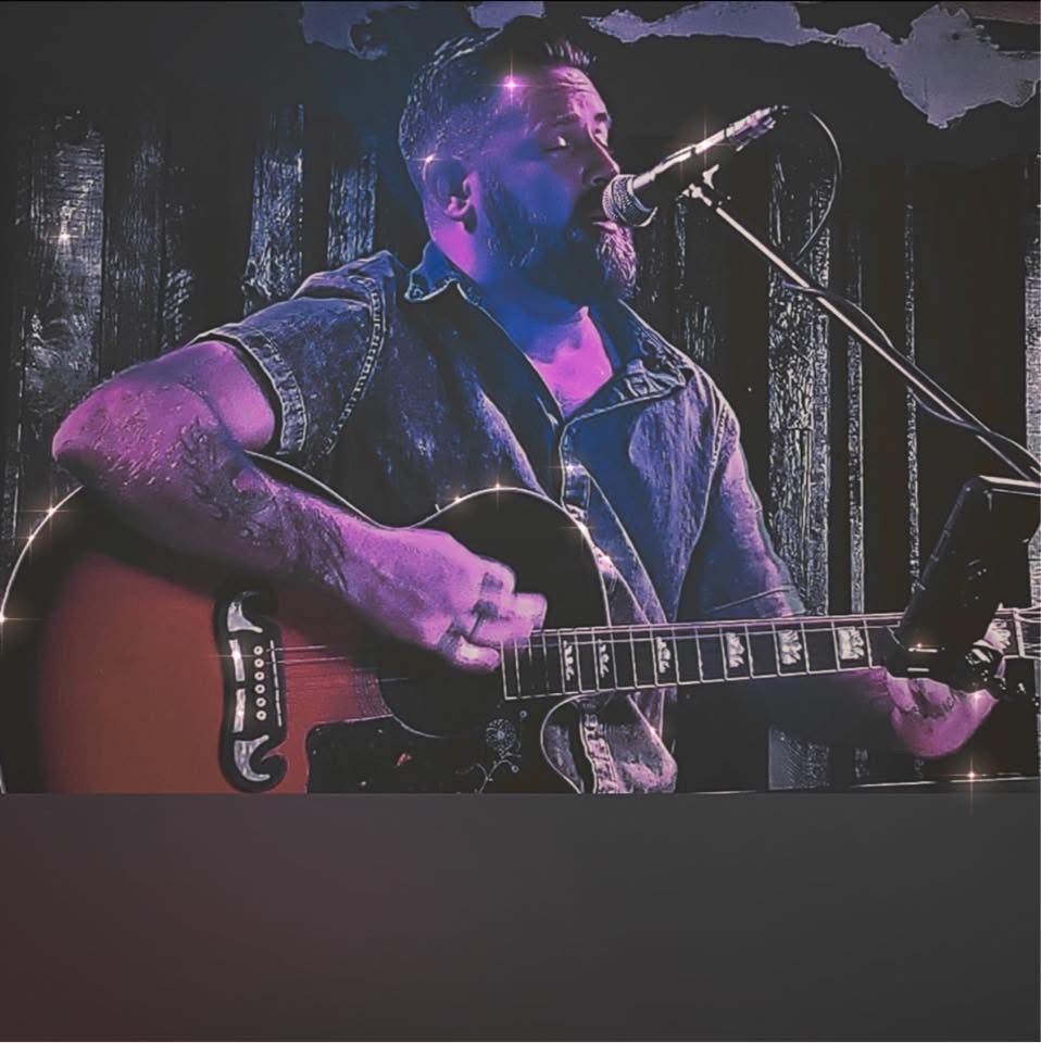 Dan Signor performing under purple stage lights